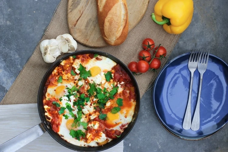 Koekenpan bovenaanzicht met ei en tomaat erin