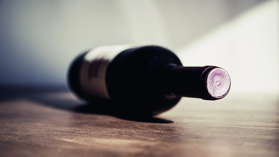 Liggende fles wijn op ondergrond van hout