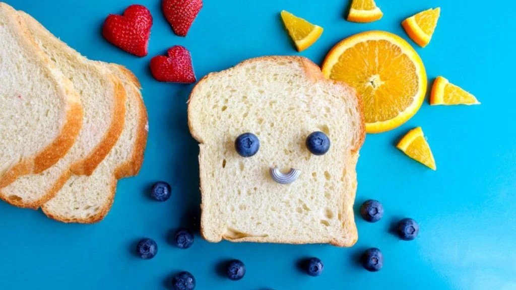 Sneetje brood met een gezichtje van fruit erop