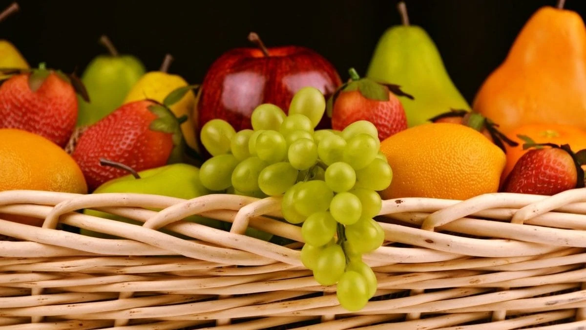 Fruitmand met druiven, appels, peren en aardbeien
