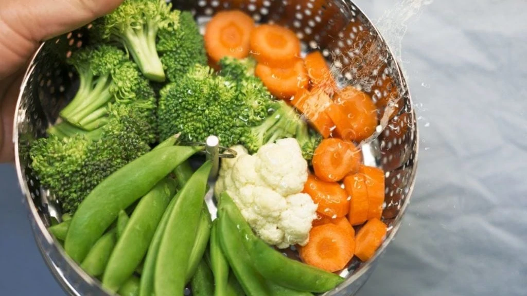 Mandje van stoomkoker met snijbonen, broccoli, wortels en bloemkool
