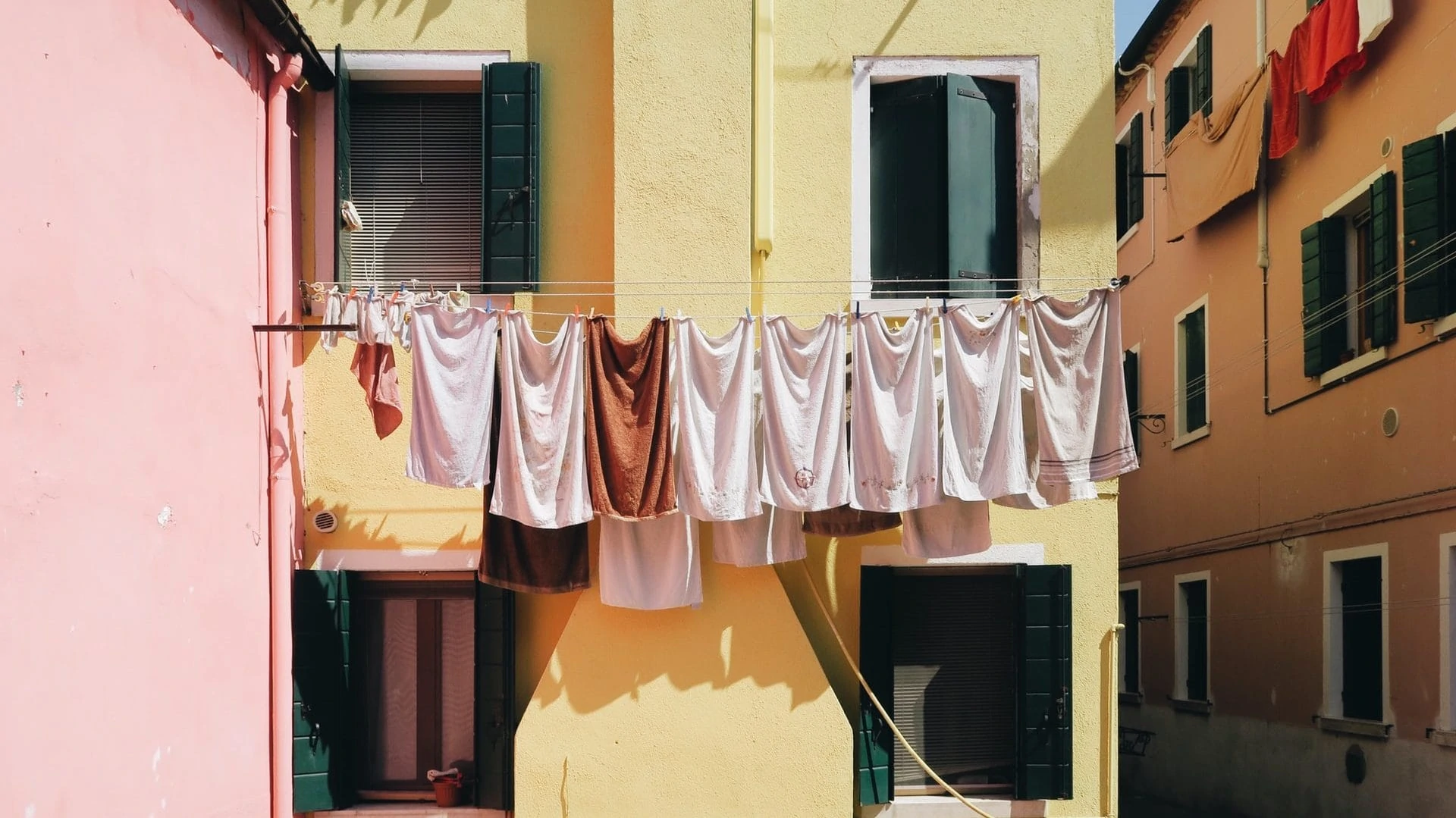 Handdoeken aan de drooglijn tussen kleurrijke gebouwen