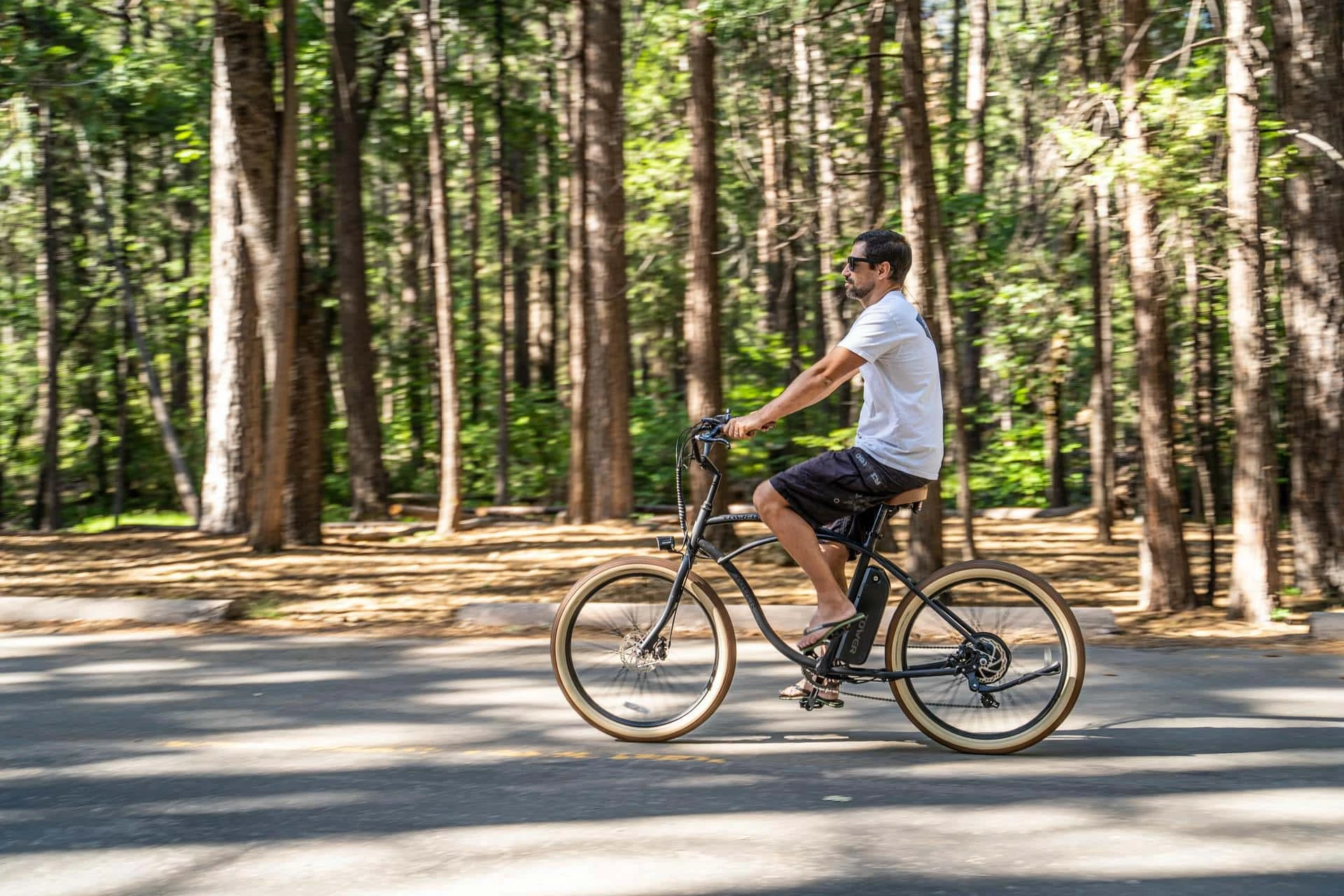 Man op elektrische fiets in bos, zij-aanzicht