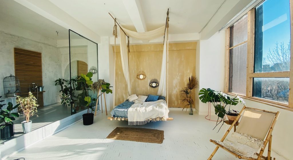 Slaapkamer met hangend bed en witte vloer
