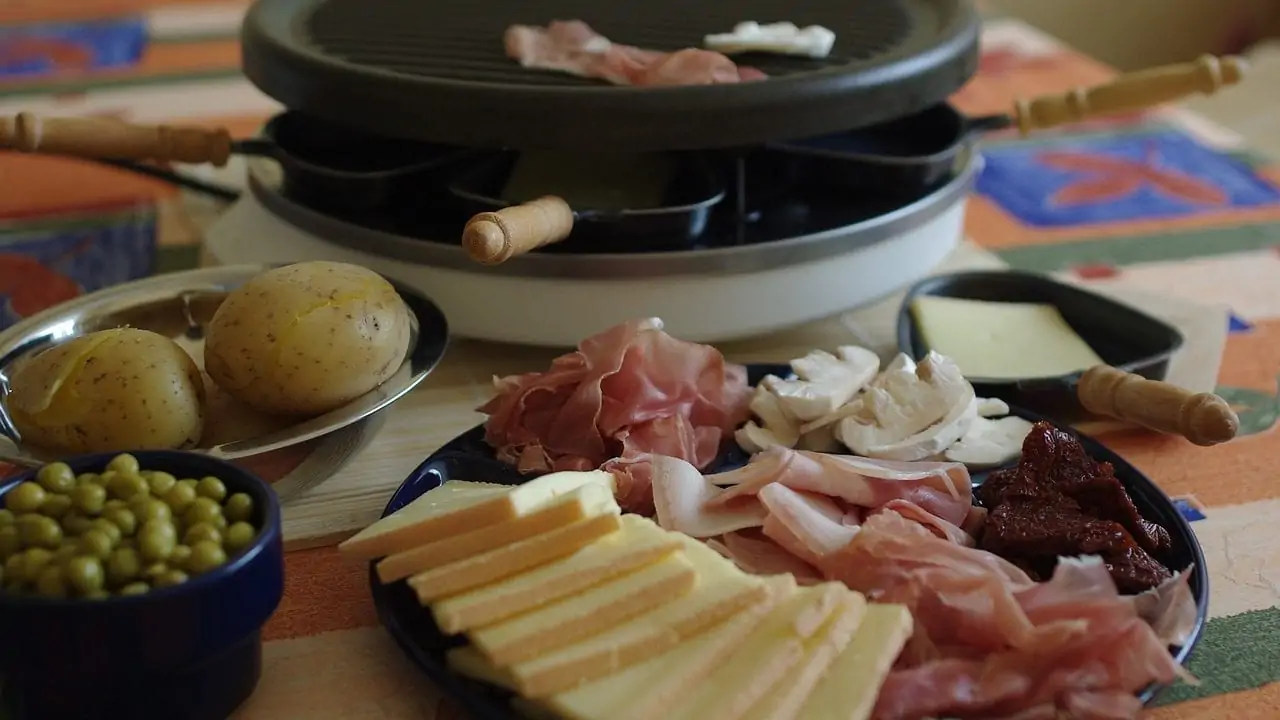 Gourmetstel en bord met plakken kaas, parmaham, champignons en rood vlees
