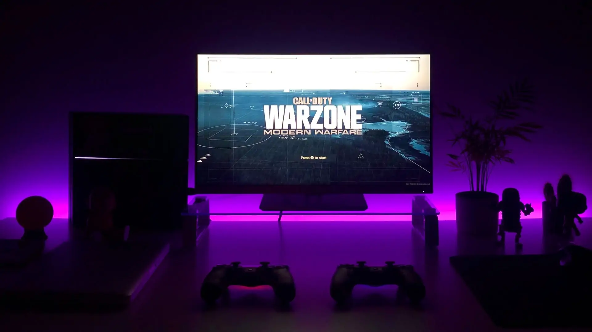 Tv op achtergrond met paarse LED verlichting, met Warzone op het scherm. Vooraanzicht
