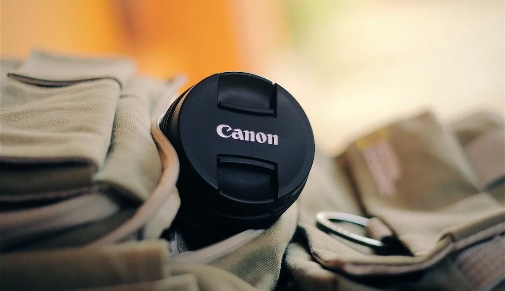 Canon camera die uit een rugzak steekt