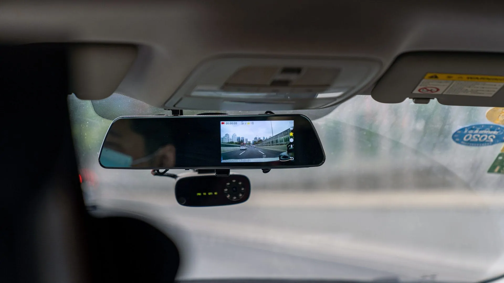 Dashcam onder achteruitkijkspiegel van auto