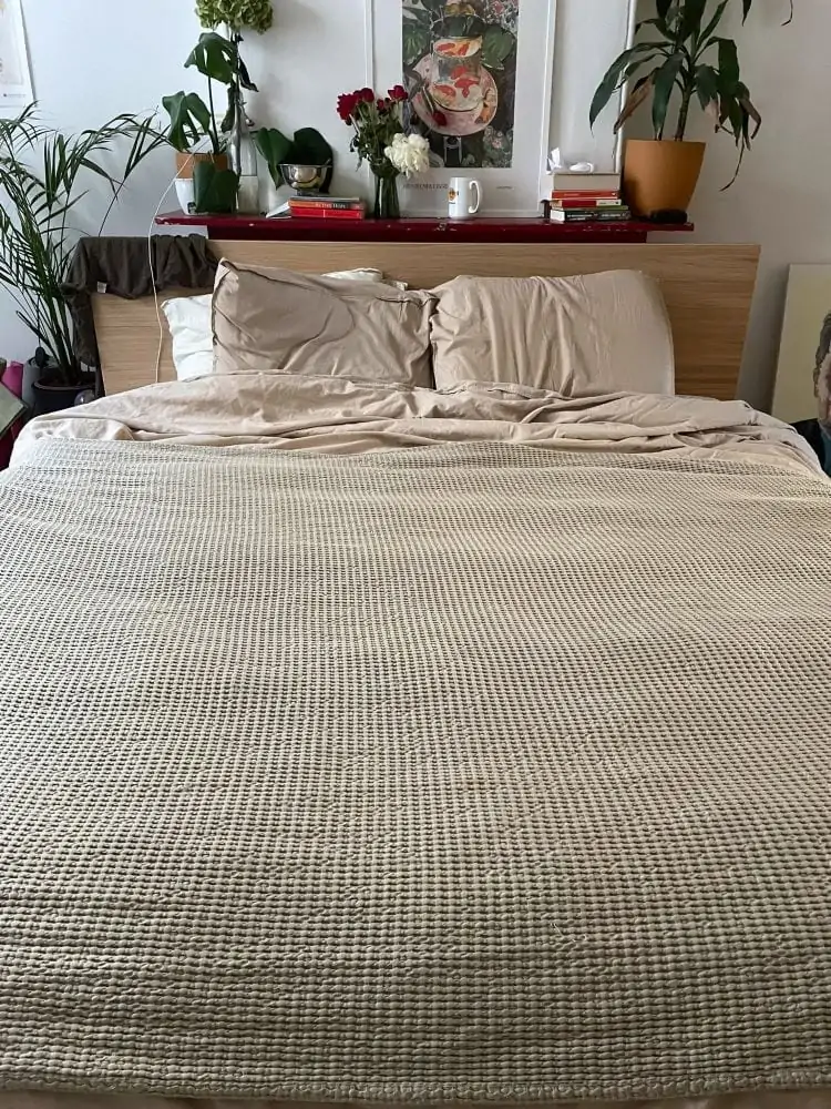 opgemaakt bed met beige beddengoed