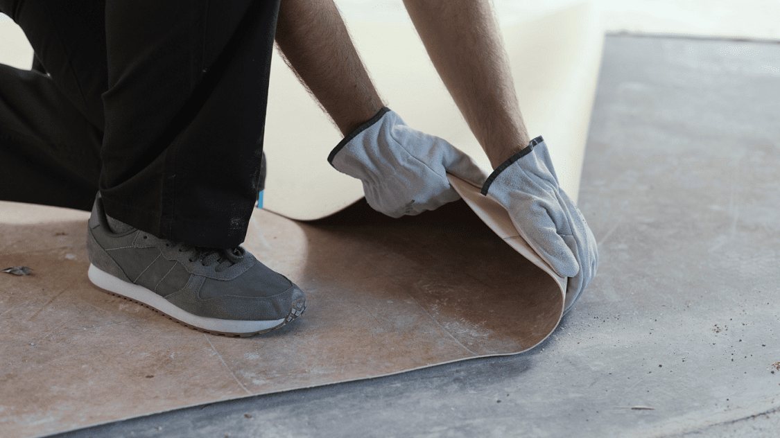 Vloerbedekking verwijderen met witte handschoenen aan