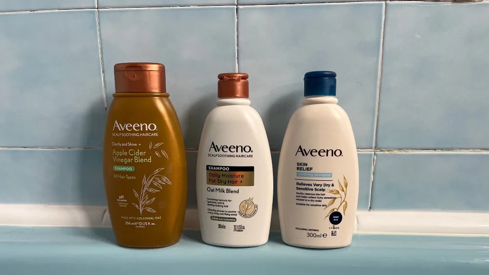 Aveeno shampoo op de rand van een bad, vooraanzicht
